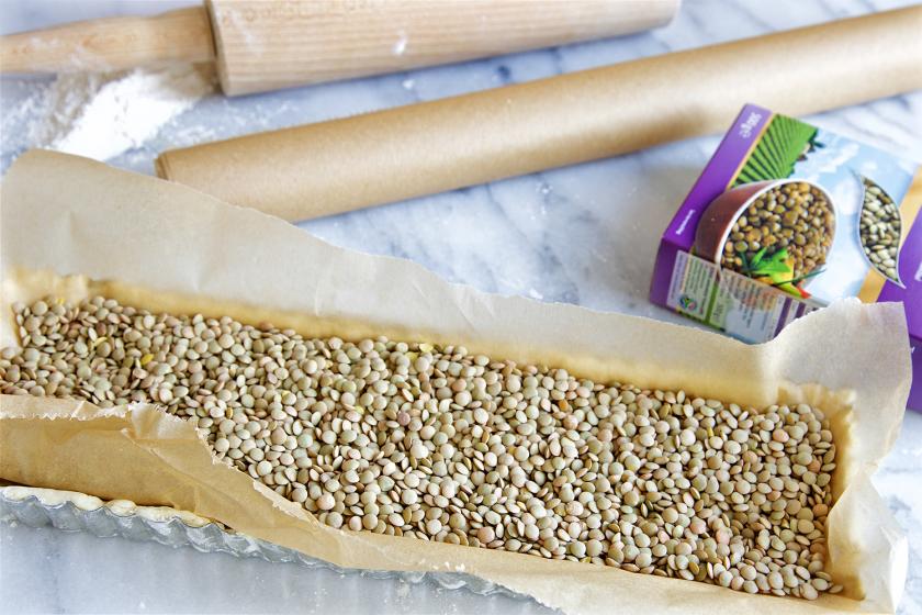 Der Teig der Kürbistarte ist in einer Form mit Blindbackkugeln beschwert.