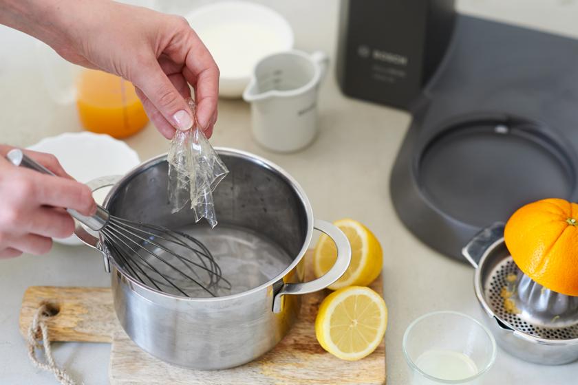 Gelatine wird in den Sirup für das Orangeneis in einen Topf gegeben.