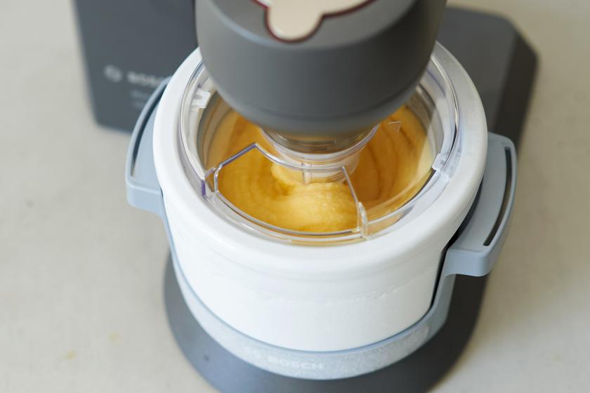 Das Orangeneis gefriert in einer Eismaschine.