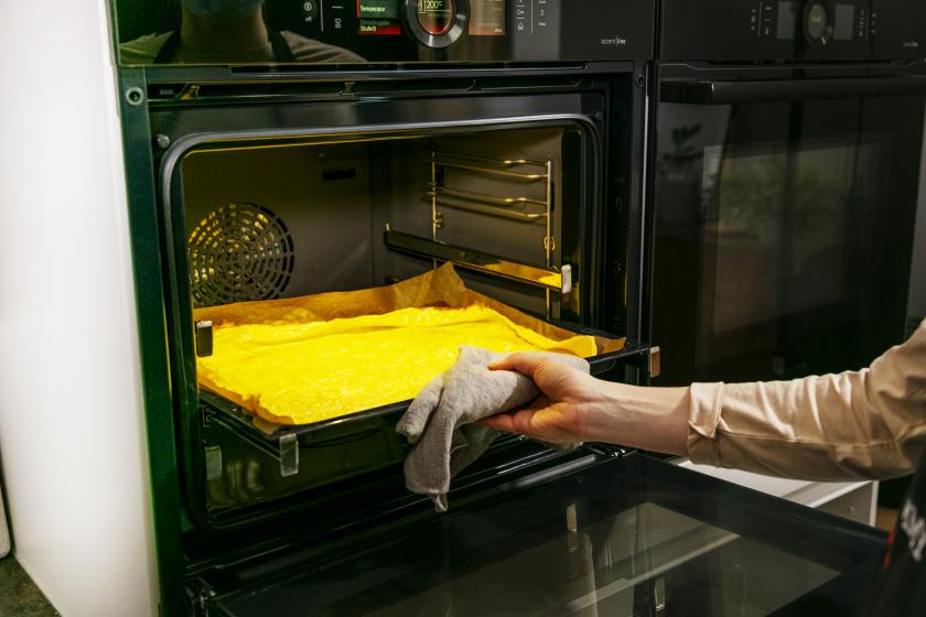 Pfannkuchenteig auf einem Blech wird in den Backofen geschoben.