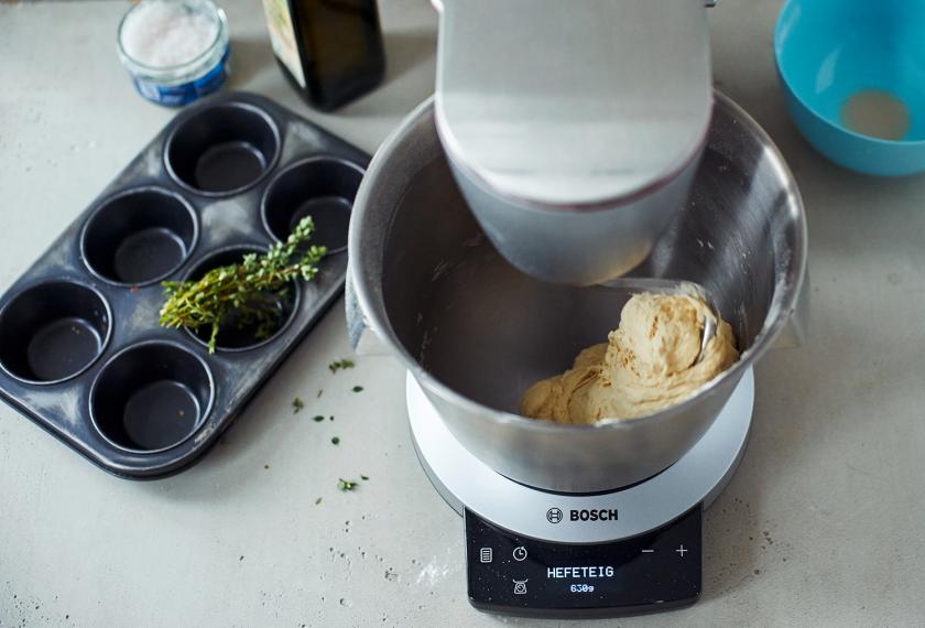 Der Teig für die Pizzaschnecken mit Pesto und Gemüse wird in einer Küchenmaschine geknetet.