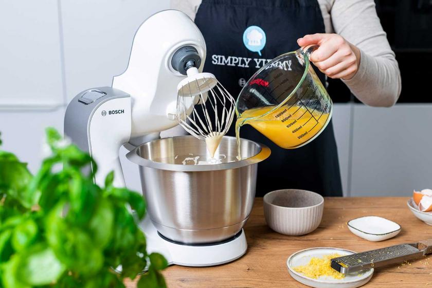 Orangensaft wird zum Teig in die Rührschüssel der Küchenmaschine gegeben.