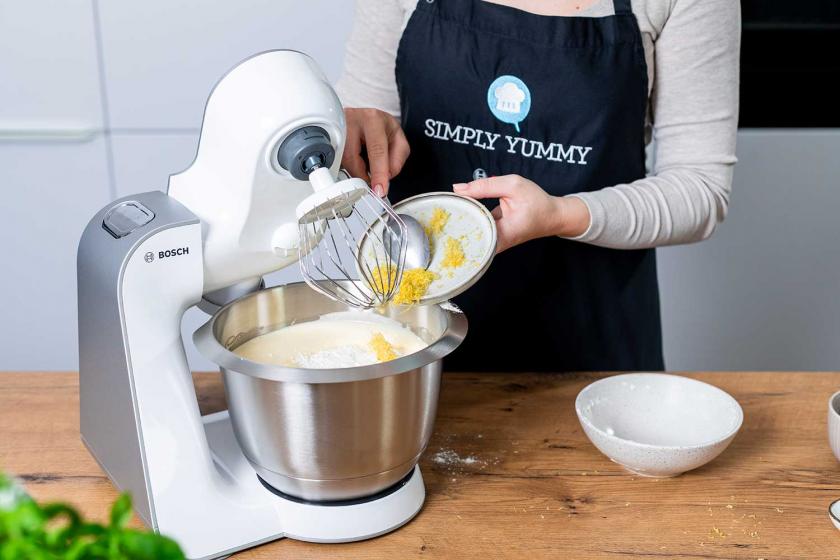 Zitronenschale wird zum Teig in die Rührschüssel gegeben.