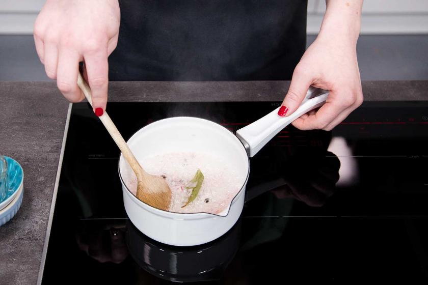 Der Gewürzsud für Sauce Hollandaise wird in einem Topf erhitzt.