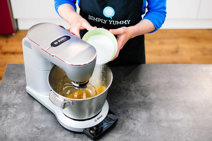 Für die Schneebälle wird Zucker in die Rührschüssel der Küchenmaschine gegeben.