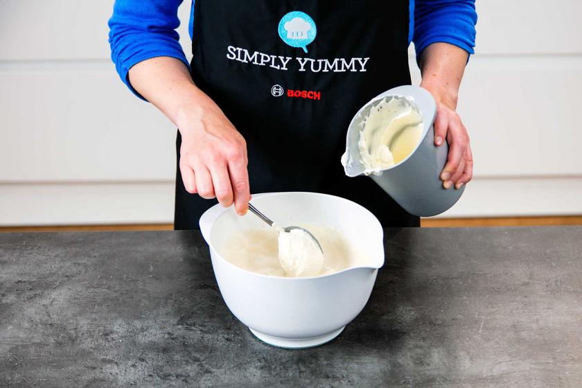 Sahne wird unter die Creme für das Schneebälle Rezept gehoben.