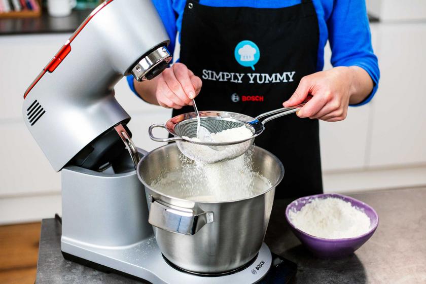 Mehl wird in die Küschenmaschine zum Teig für das Schneebälle Rezept gegeben.