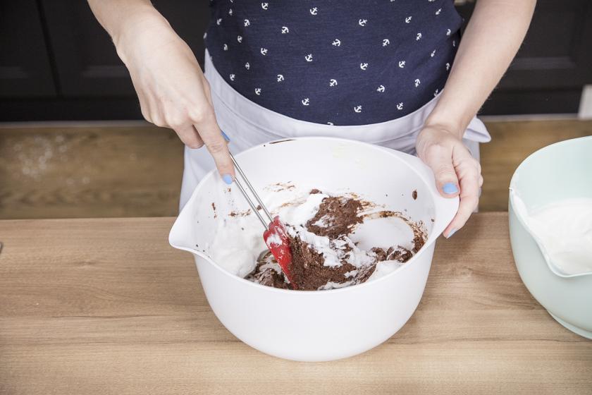 Eischnee wird unter den Schoko-Kirsch-Kuchen gehoben.