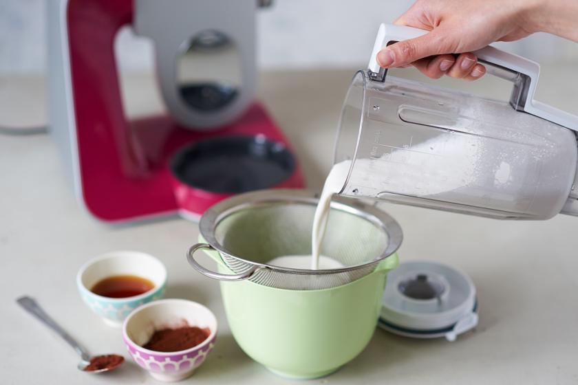 Mandelmilch für die Schoko-Mandelmilch wird durch ein Sieb gegossen.