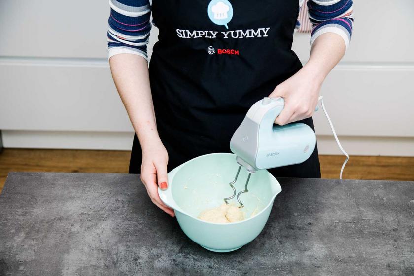 Strudelteig wird mit einem Handmixer geknetet.