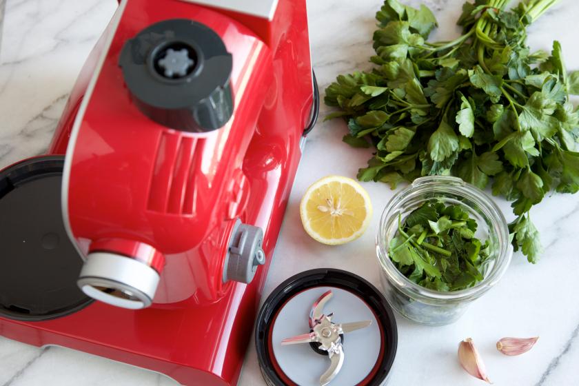 Kräuter werden in einer Küchenmaschine für das Hähnchen-Spargel-Päckchen zerkleinert.