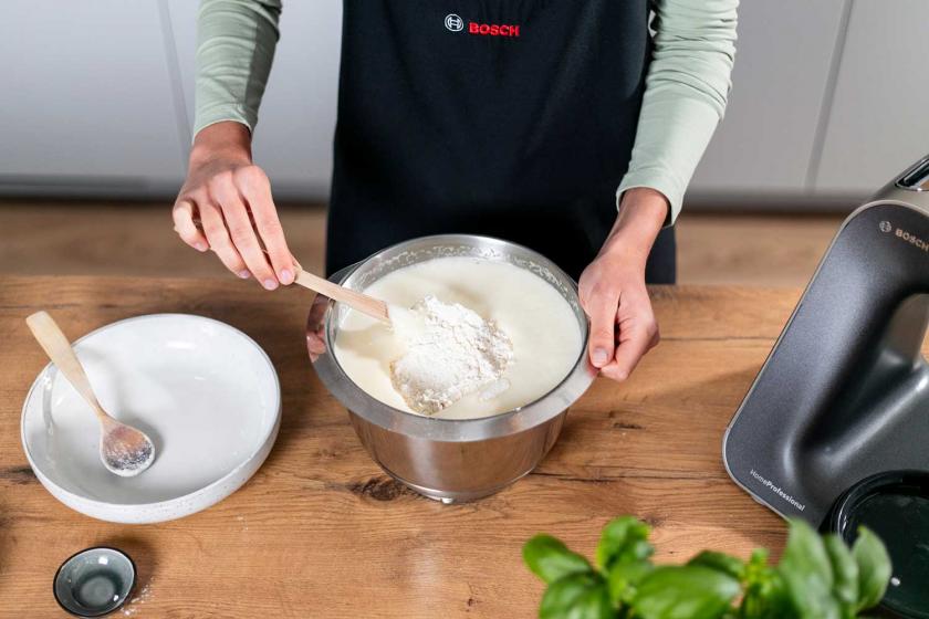 Für den Teig des Zitronenkuchens vom Blech wird Mehl unter die Eimasse gerührt.