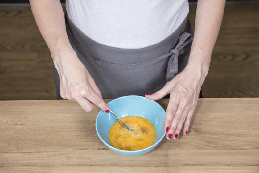 Eier werden für die Zwiebelkuchen-Füllung in einer Schüssel verquirlt.