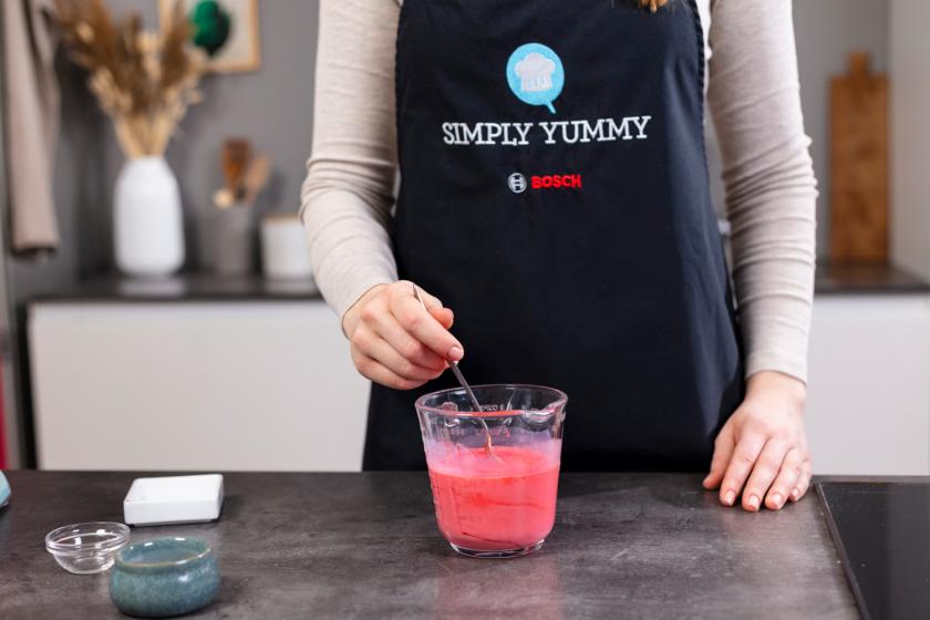 Buttermilch wird mit roter Lebensmittelfarbe verrührt.