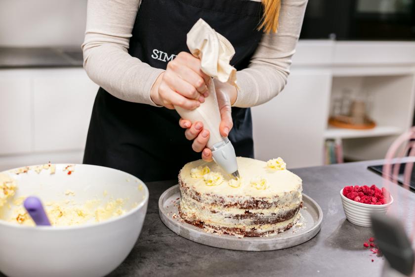 Red Velvet Cake wird mit Frischkäse-Tupfen dekoriert.