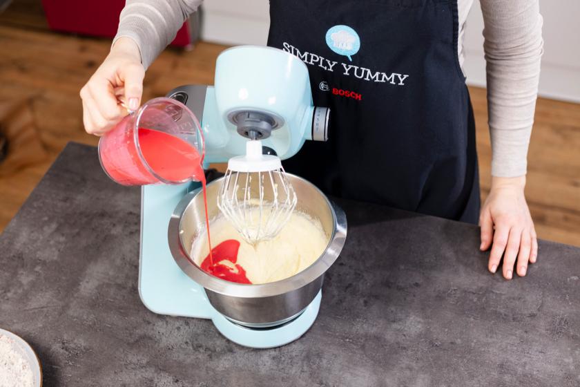 Rote Buttermilch-Mischung wird zum Teig für den Red Velvet Cake gegeben.