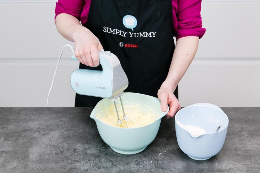 Der Teig für den Regenbogenkuchen wird mit einem Handmixer in einer Schüssel verrührt.