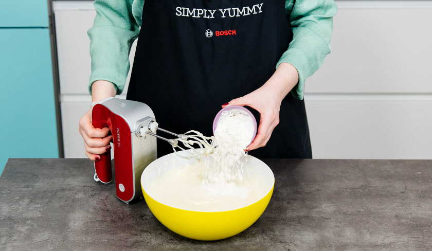 Für den Rhabarberkuchen mit Quark wird die Füllung in einer Schüssel mit einem Handrührer vermixt.