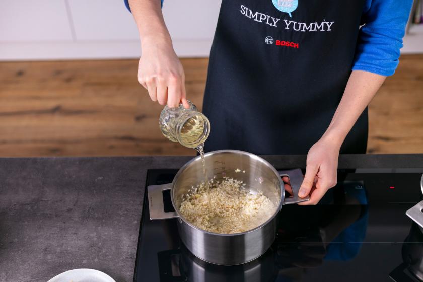 Risotto wird mit Weißwein abgelöscht.