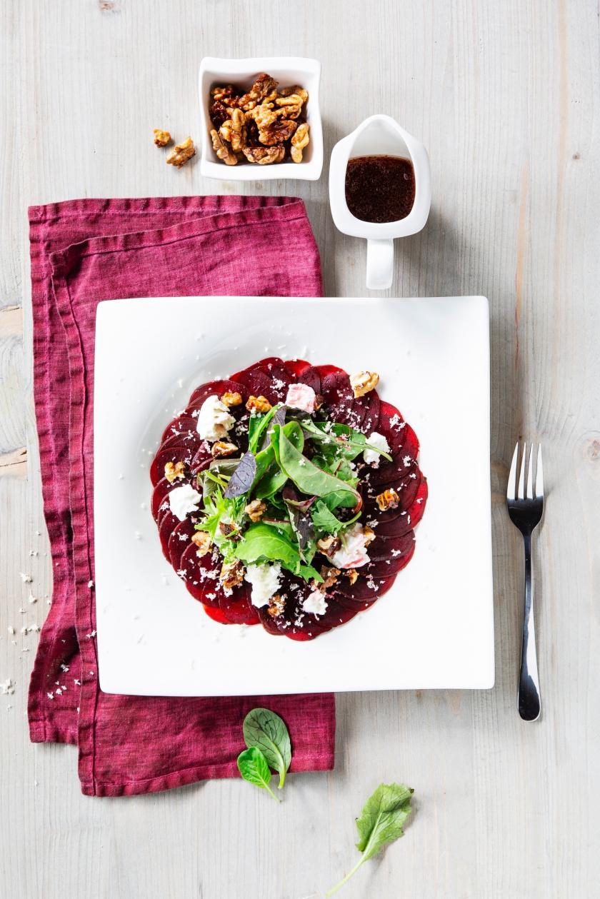 Teller mit Rote Bete Carpaccio und Ziegenkäse auf Serviette.