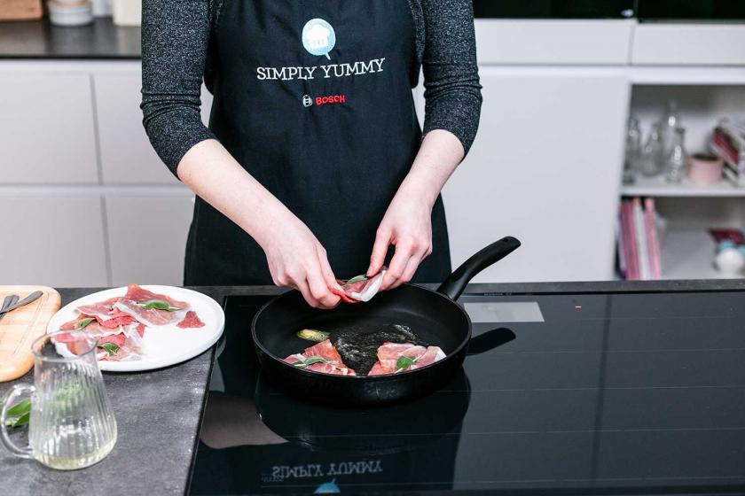 Saltimbocca alla romana werden in die Pfanne gelegt zum Braten.