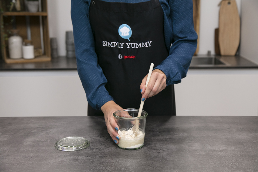 Für das Sauerteigbrot wird der Sauerteigstarter in einem Glas angerührt.