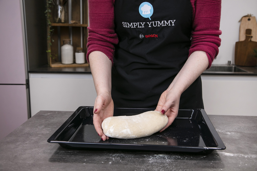 Das Sauerteigbrot wird auf ein Backblech gelegt.