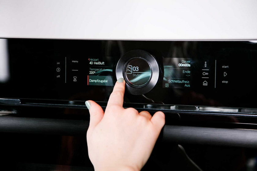 Jemand schaltet den Ofen zum Backen des Sauerteigbrots an.