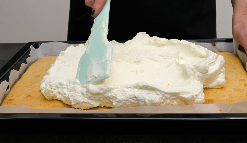 Die Schmandcreme für die Schmandschnitten mit Glühweinkirschen wird auf dem Boden verteilt.