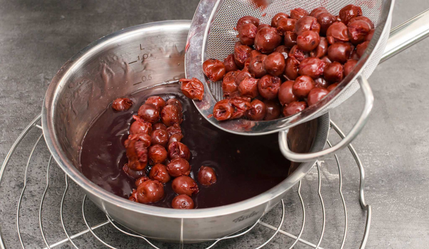 Die Kirschen für die Schmandschnitten mit Glühweinkirschen werden zum Glühwein in eine Schüssel gegeben.