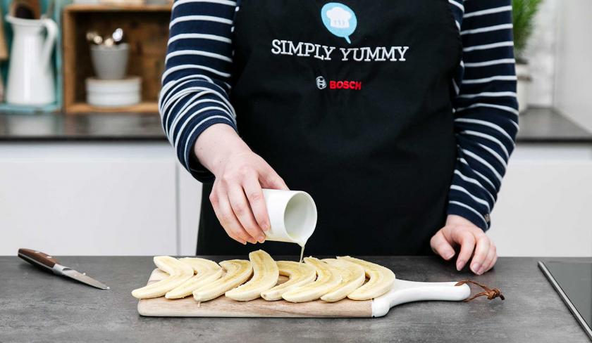 Bananen werden mit Zitronensaft beträufelt.