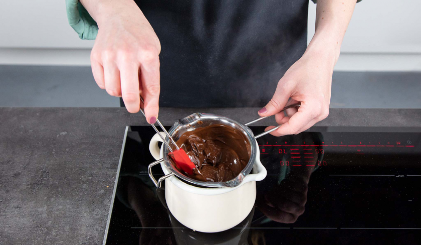 Für den Schoko-Käsekuchen wird Schokolade über einem Wasserbad geschmolzen.