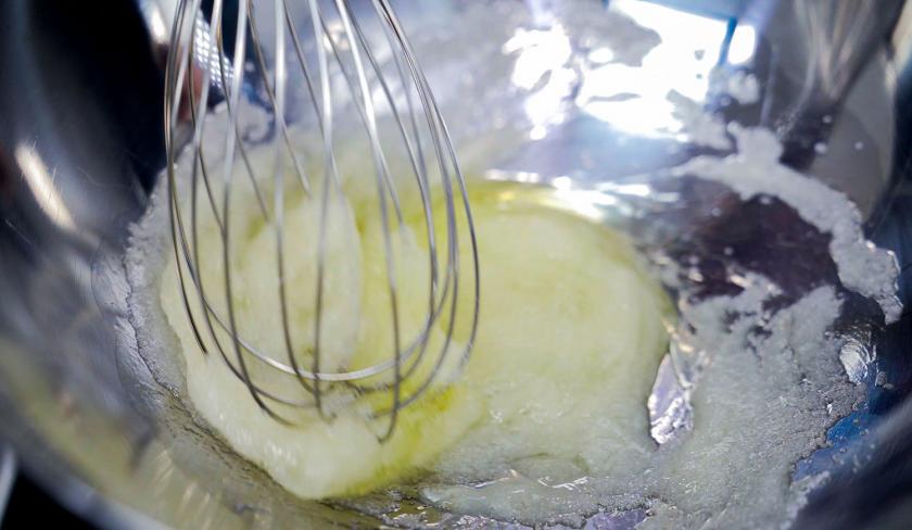 Für das Topping der Schoko-Kirsch-Muffins wird Eiweiß mit Zucker mit einem Schneebesen verrührt.