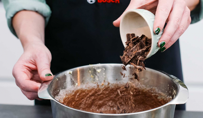 Für den Schoko-Nusskuchen mit Cheesecake-Frosting wird Schokolade zum Teig gegeben.
