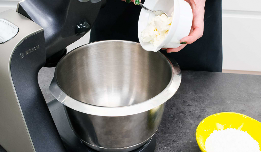 Für den Schoko-Nusskuchen mit Cheesecake-Frosting wird Frischkäse in eine Rührschüssel gegeben.
