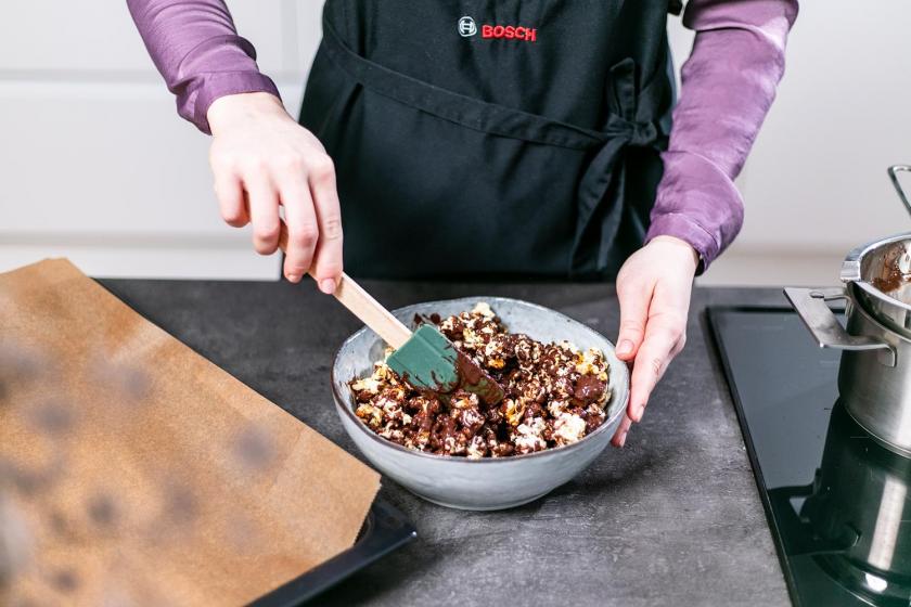Popcorn und Schokolade werden in einer Schüssel vermengt.