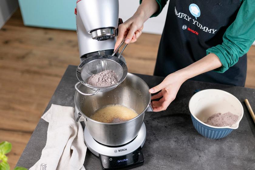 Mehlmischung wird auf den Teig in der Rührschüssel gesiebt.