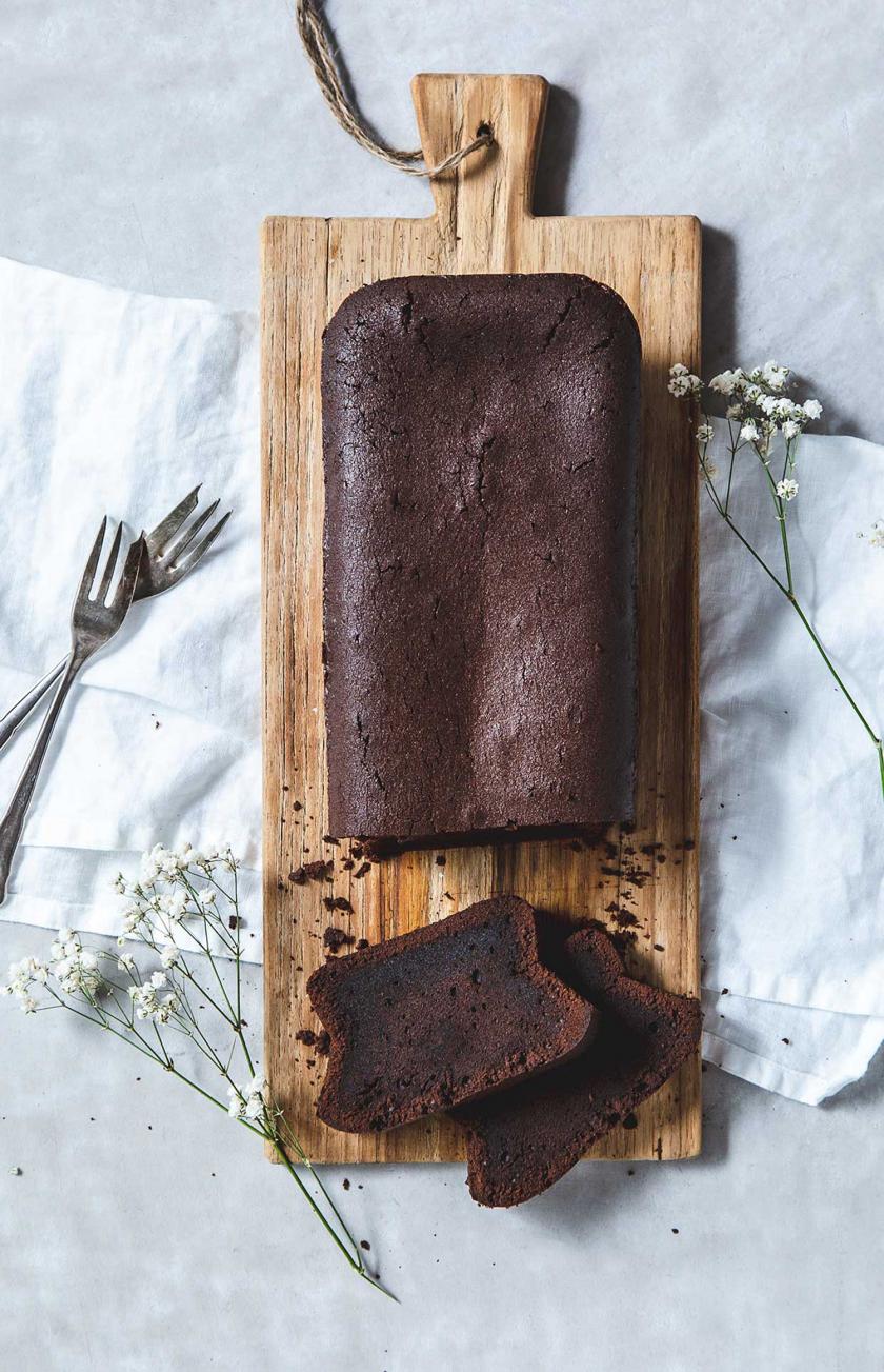 Schokokuchen mit Öl angeschnitten auf einem Holzbrett.