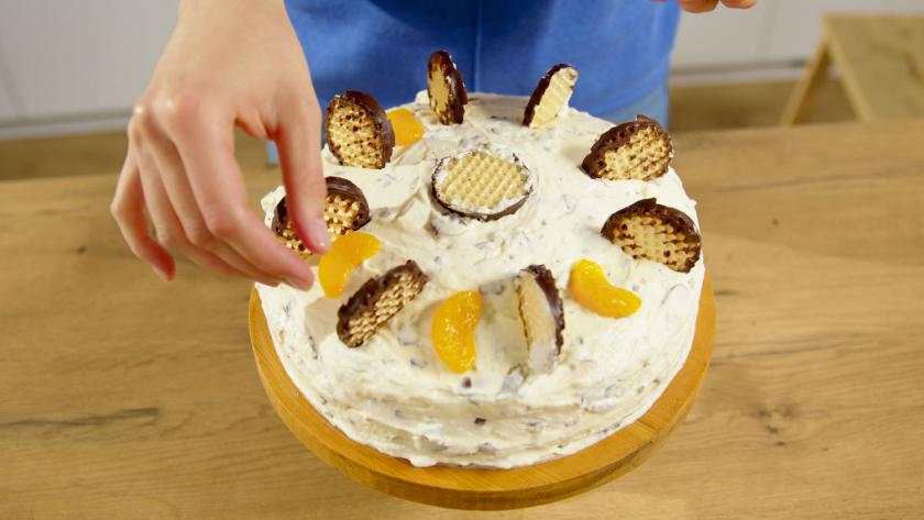 Schokokusstorte mit Mandarinen wird dekoriert.