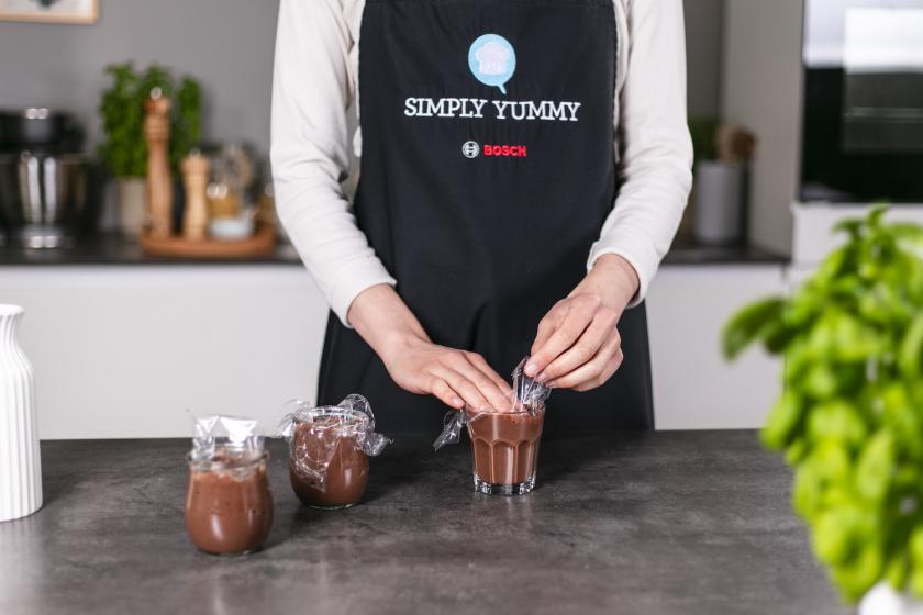 Selbst gemachter Schokopudding wird mit Frischhaltefolie abgedeckt.