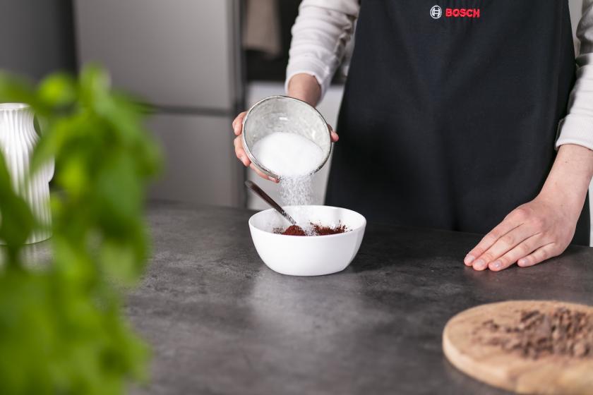 Zucker wird in eine Schale gegeben.