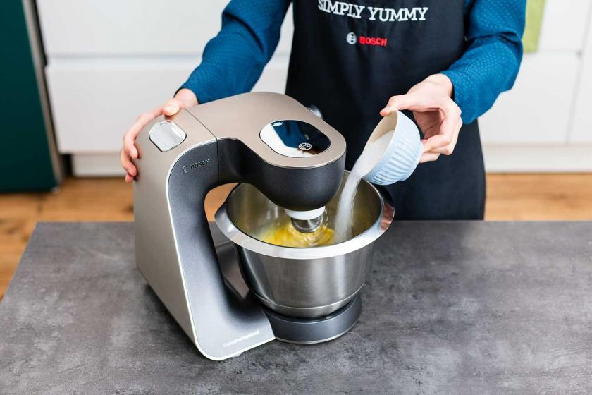 Zucker wird in die Rührschüssel einer Küchenmaschine gegeben.