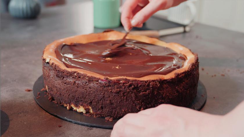 Die Schwarzwälder Käsetorte wird mit einer Ganache bedeckt.
