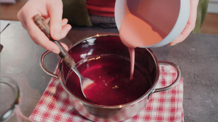 Für das Kirschkompott der Schwarzwälder Käsetorte wird angerührtes Puddingpulver zum aufgefagenen Kirschsaft in den Topf eingerührt.