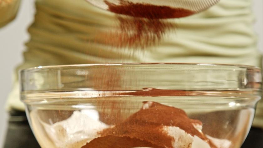 Kakao wird zu Mehl in eine Schüssel gesiebt.