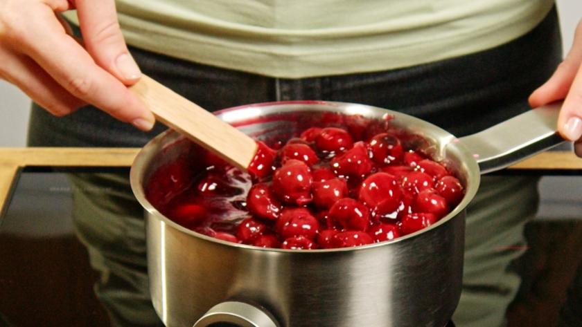 Kirschen werden in einem Topf erhitzt.