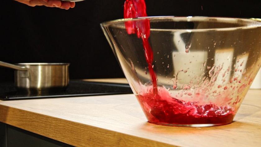 Kirschsaft wird in einer Schüssel aufgefangen.