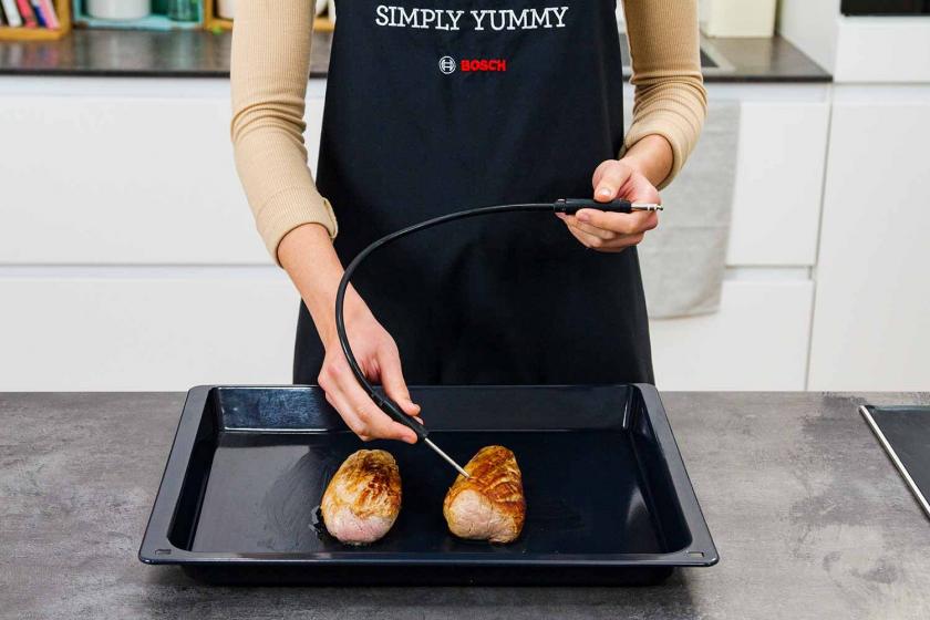 Ein Bratenthermometer wird in das Schweinefilet gesteckt.