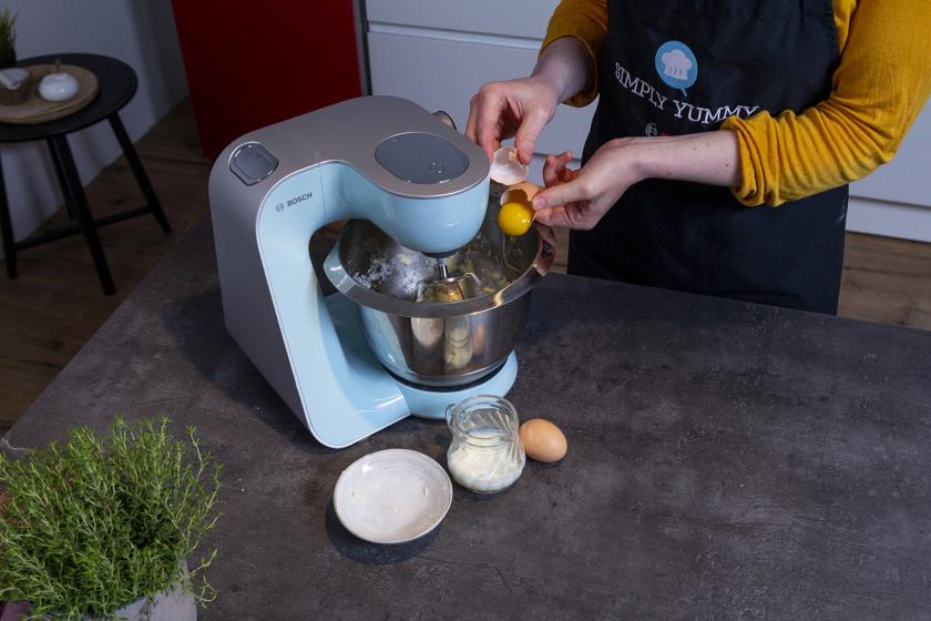 Eier werden in die Rührschüssel einer Küchenmaschine gegeben.