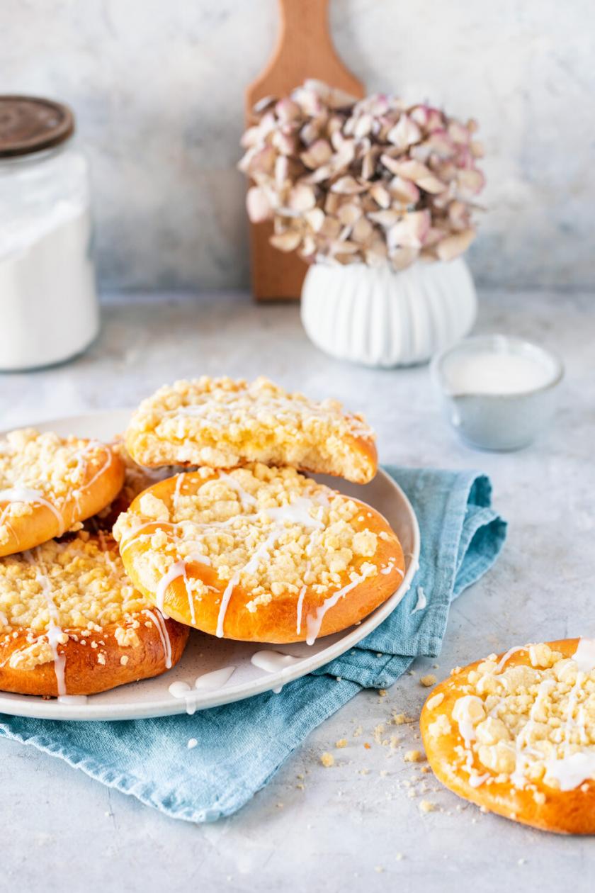 Vier Streuseltaler mit Zuckerguss gestapelt auf einer Kuchenplatte
